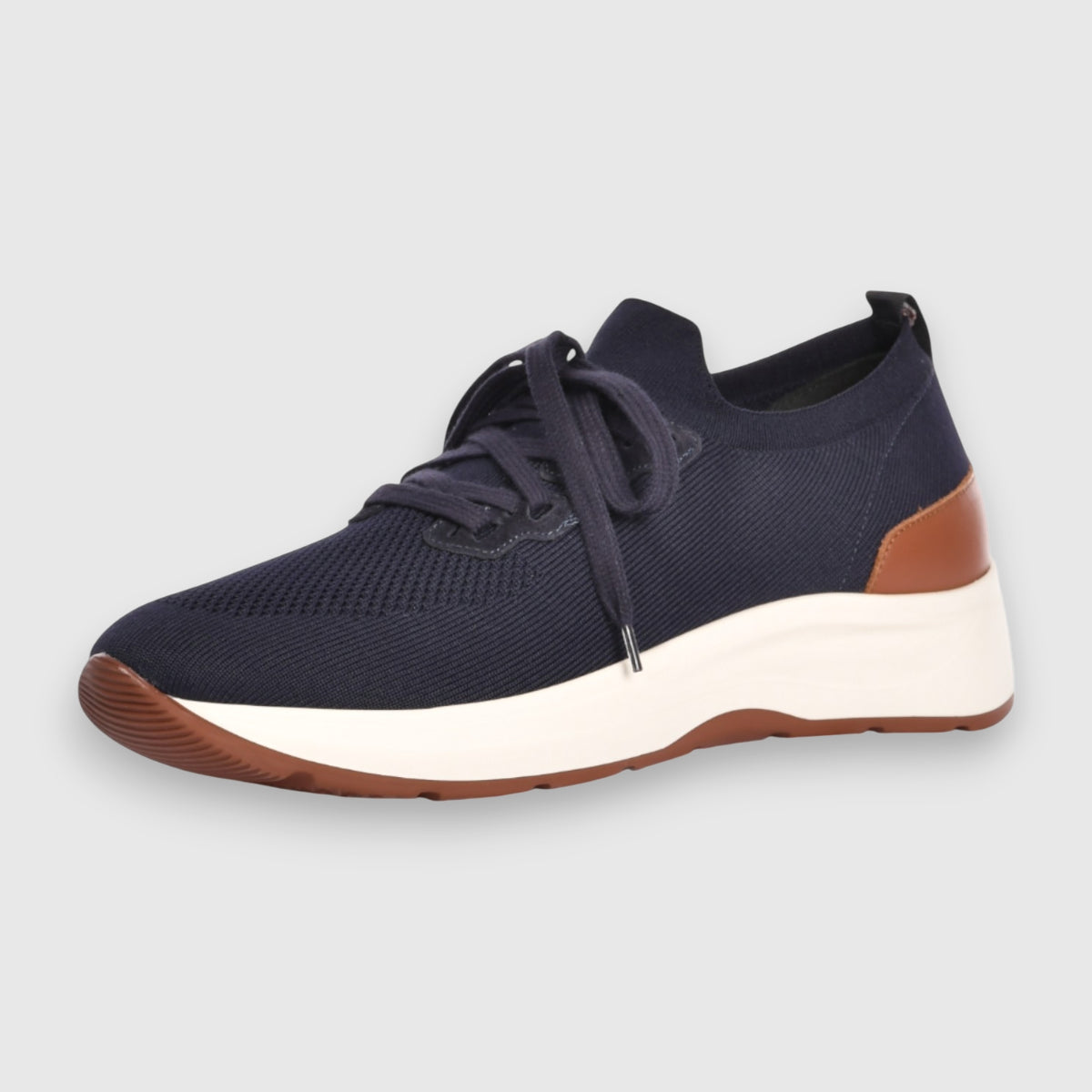 The Gran Sasso Navy Blue Knitted Sneakers feature a mesh upper, white thick sole, brown heel accent, brown outsole detail, and navy laces. Their modern sporty design is highlighted against a light gray background. , available at Richard Gelding Mayfair