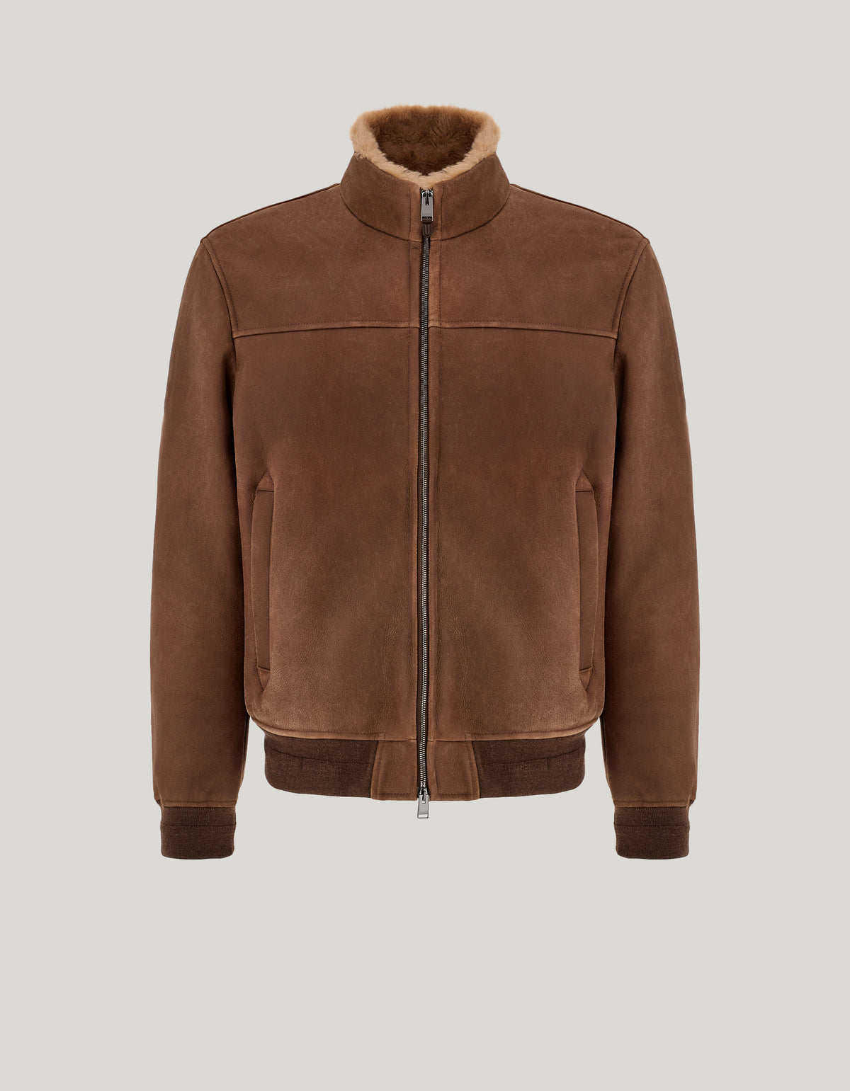 The Canali Brown Merino Shearling Lambskin Suede Blouson features a front zipper, shearling-lined collar, ribbed cuffs and hem, and two side pockets, showcased against a neutral gray background. , available at Richard Gelding Mayfair
