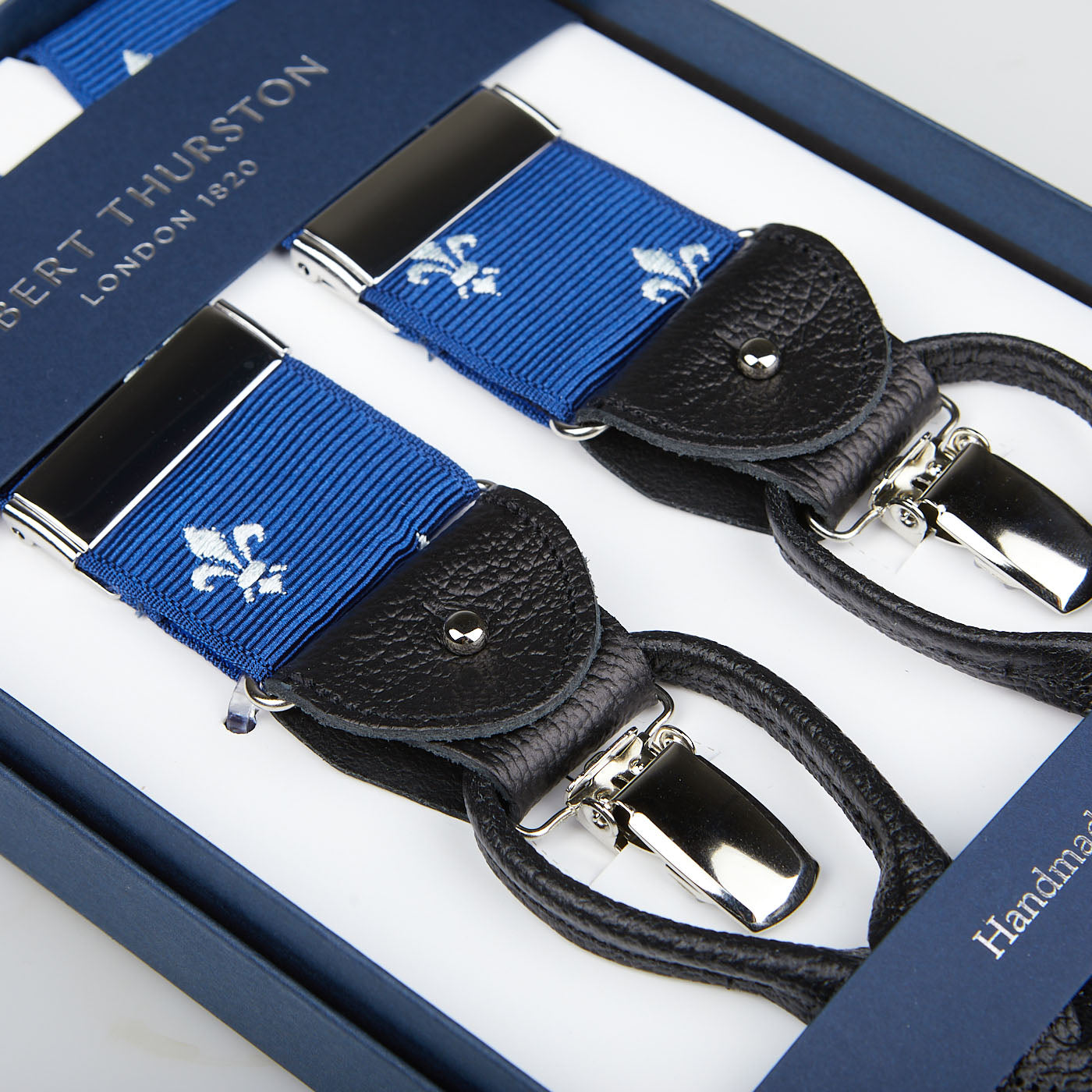 Albert Thurston's Blue with White French Lily 40mm Braces feature silver clips and leather accents in a presentation box, adding elegance to any wardrobe.
