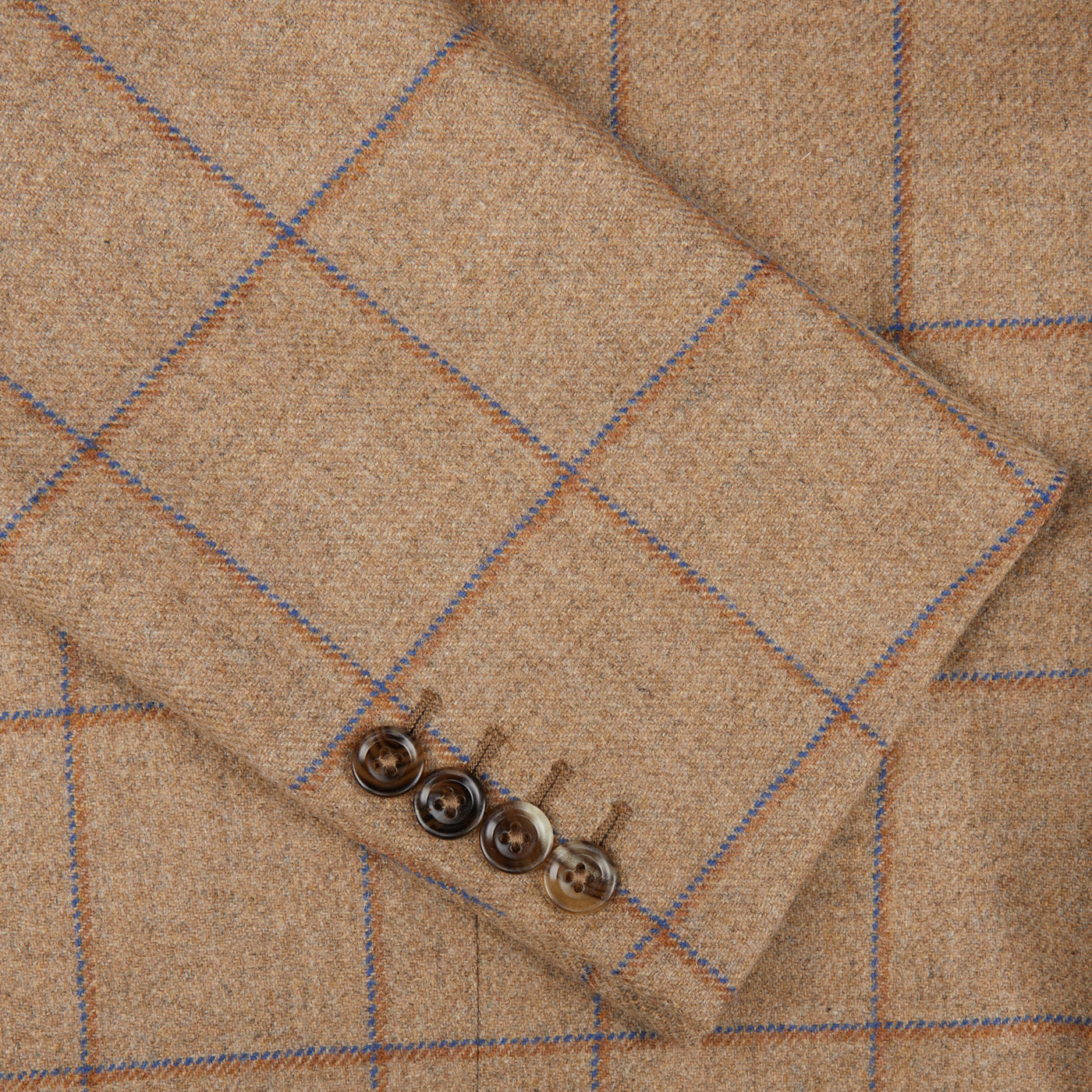 A close up of a Caramel Estate Wool Tweed Provence Jacket with blue buttons, designed by Alexander Kraft Monte Carlo.