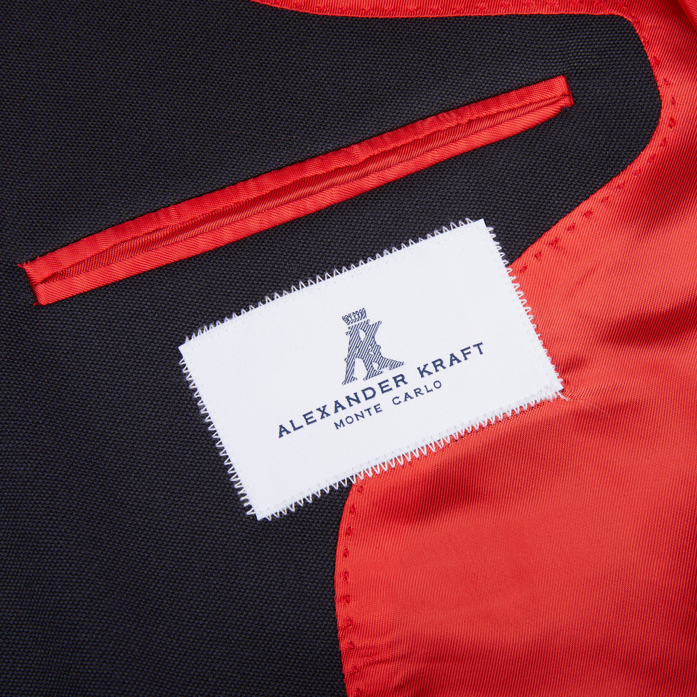 An Alexander Kraft Monte Carlo Navy Blue Textured Worsted Wool Signature Jacket in black and red with a label on it.