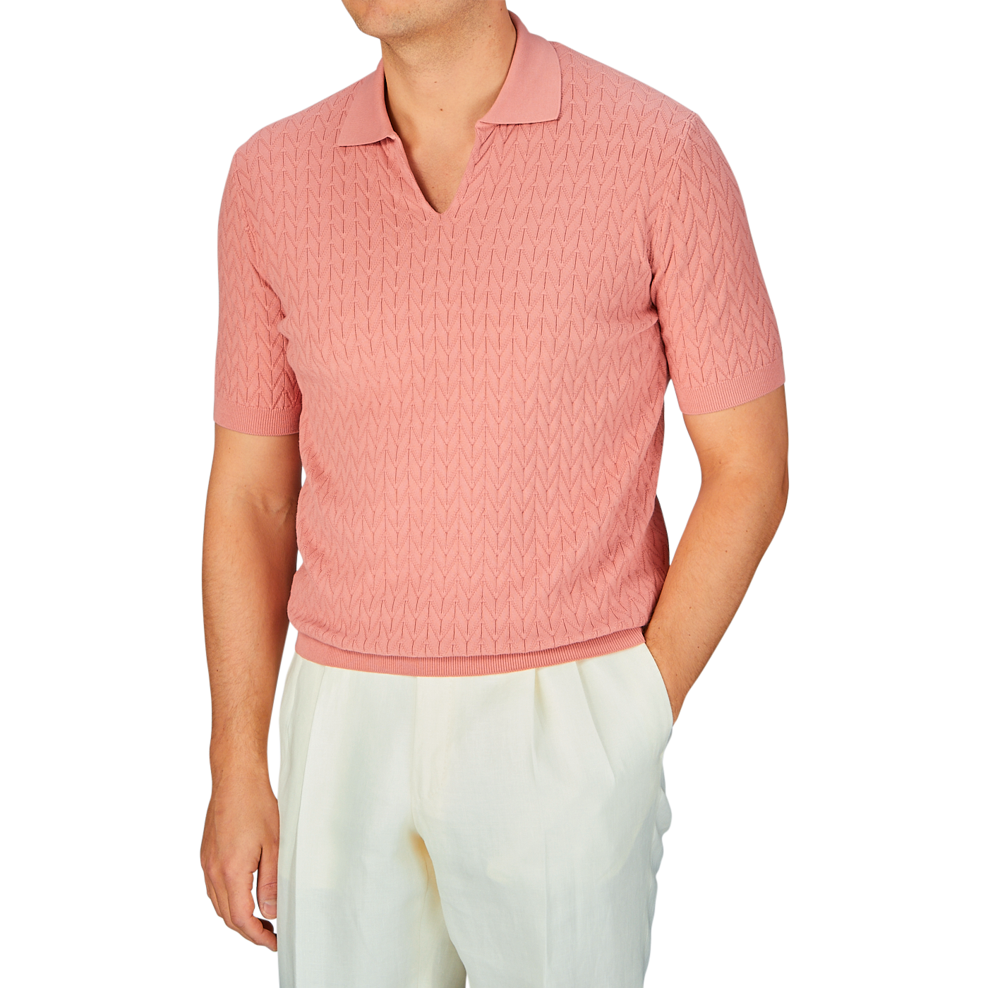 Man wearing a Altea muted pink cotton capri collar polo shirt with a chevronne knit pattern and light-colored trousers.