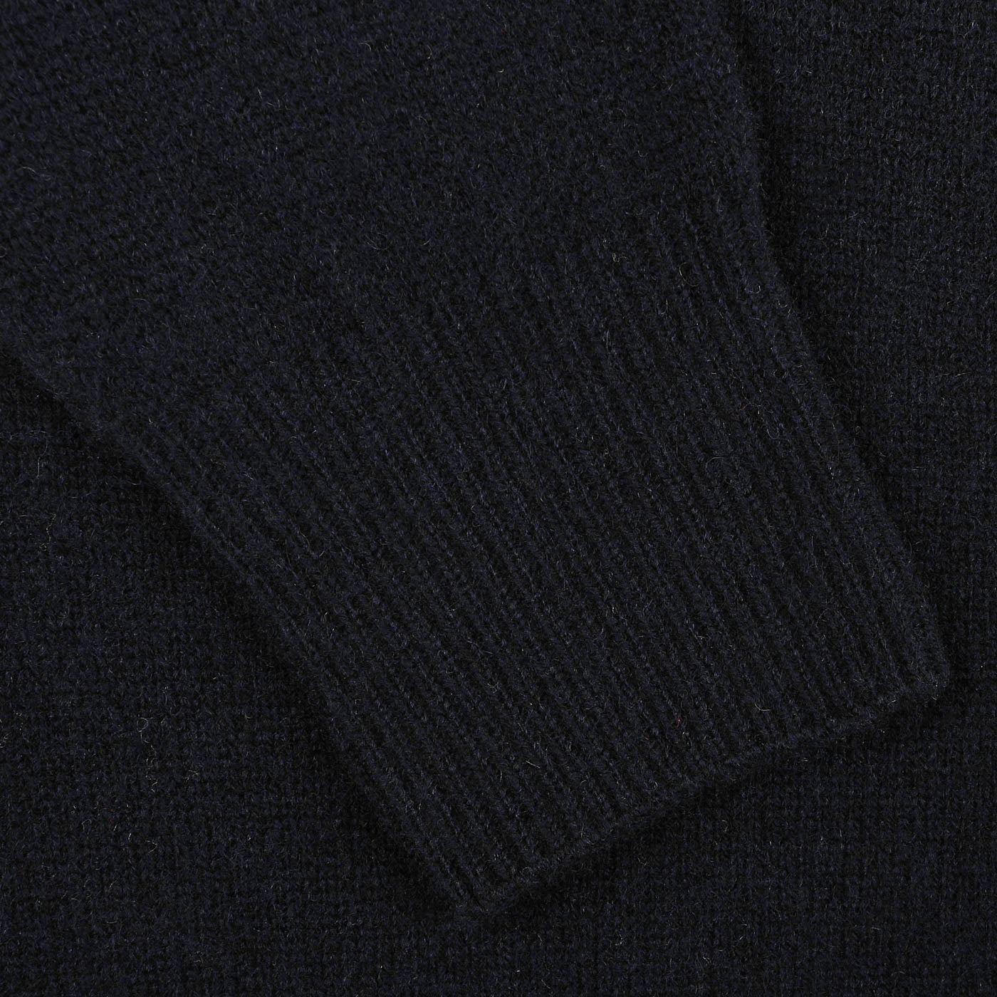 Close-up of the ribbed cuff on the sleeve of an Altea Navy Blue Shetland Wool Button Cardigan, crafted from luxurious Shetland wool.