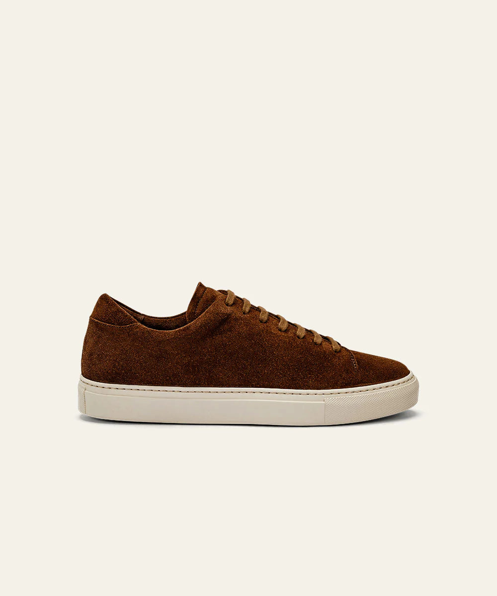 The Azaleri Brown Suede Sneakers Cannaregio feature a minimalist, modern low-top design with matching brown laces and a white rubber sole, shown in profile against an off-white background and no visible branding. , available at Richard Gelding Mayfair
