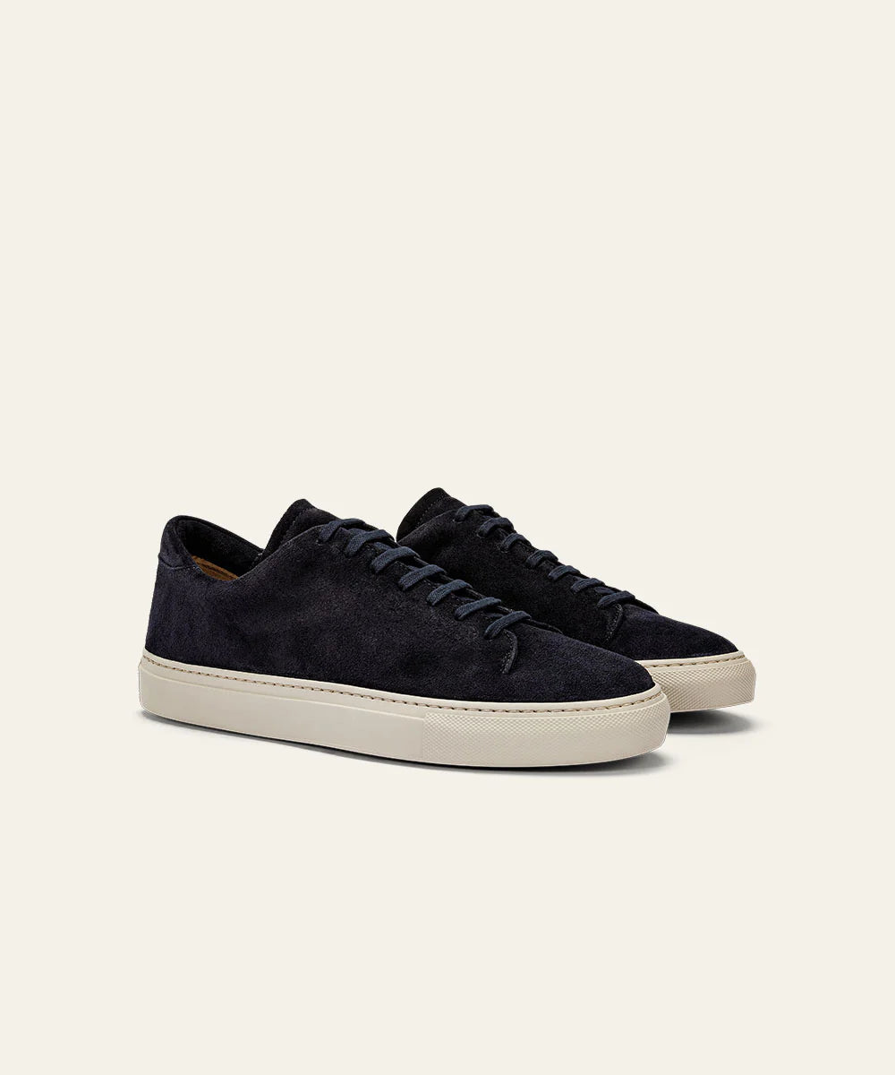 The Azaleri Midnight Blue Suede Sneakers Cannaregio feature matching navy laces and off-white rubber soles, shown angled to display both side and front views against a light beige background. , available at Richard Gelding Mayfair