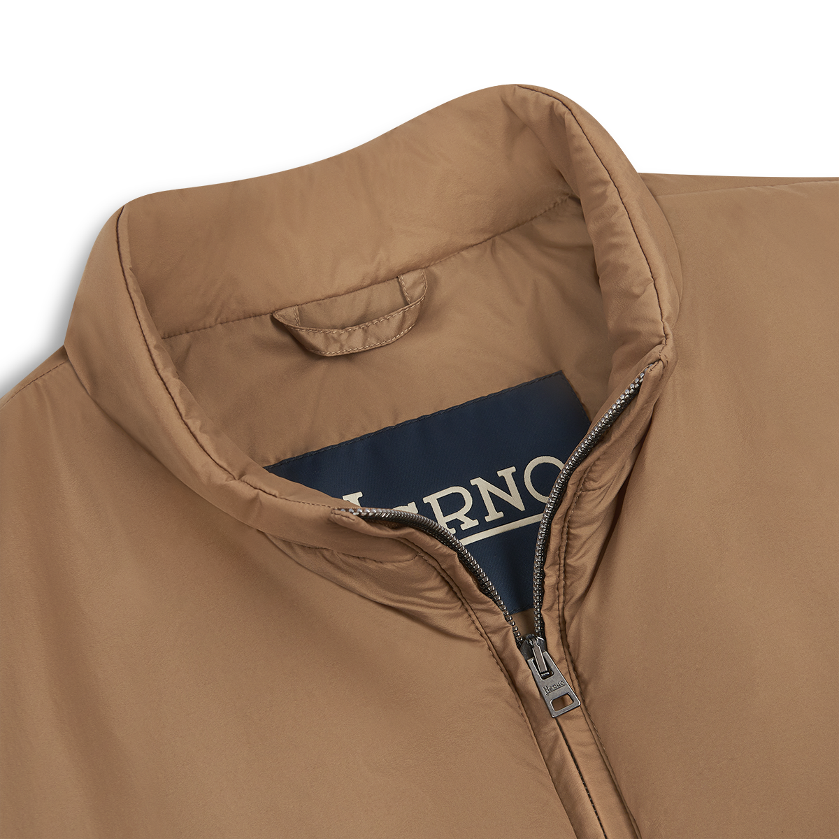 A close-up of the Herno Camel Brown Lightweight Nylon Gilet with a stand-up collar and visible silver zipper, partially unzipped, showing a navy Herno label inside against a plain white background—a stylish outerwear piece. , available at Richard Gelding Mayfair