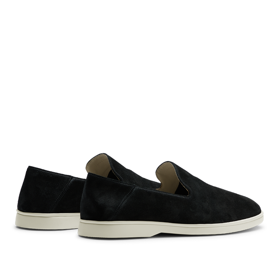 A pair of CQP black suede leather Vice loafers with white soles displayed on a horizontal surface against a striped background.