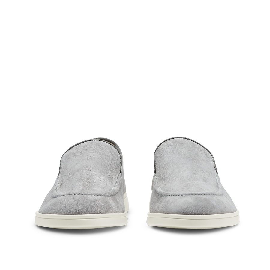 A pair of Cement Grey Suede Leather Debonair Loafers from CQP, with white soles, viewed from the rear.
