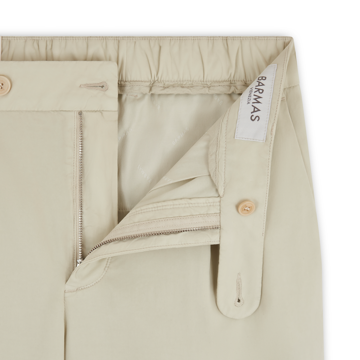 Close-up of Cream Cotton/Silk Stretch Waistband Chinos by Barmas, featuring an elastic waistband, partially open zipper, button closure, and visible stitching that highlights the quality construction. Inner label reads "Barmas. , available at Richard Gelding Mayfair