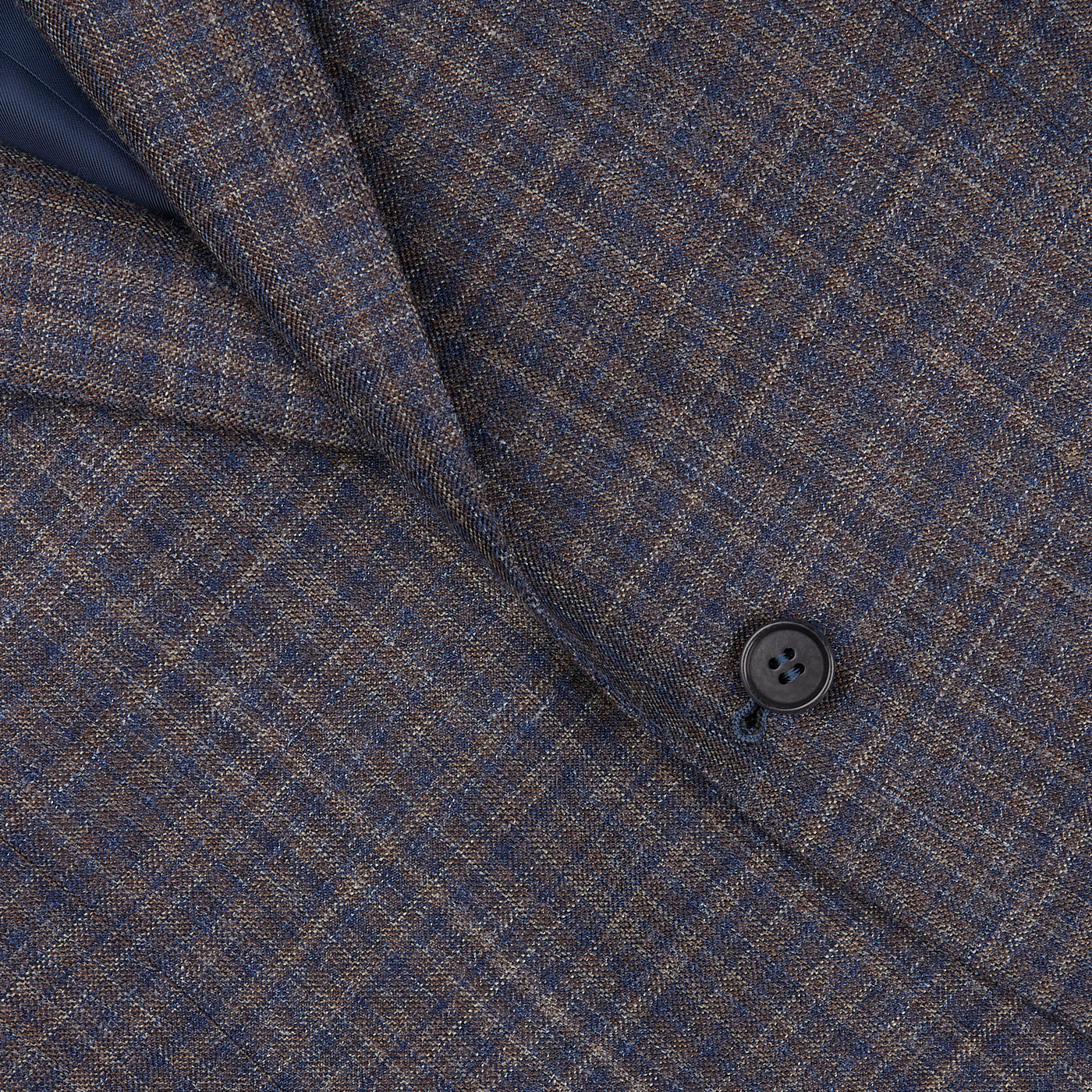 Close-up of a textured blue gingham checked wool silk linen Canali blazer with a visible button, highlighting the detailed weave and pattern.