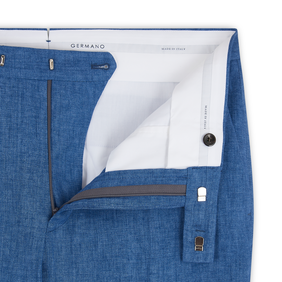 Close-up of Germano Blue Linen Formal Trousers with open waistband showing white lining, button, zip fly, and hook-and-bar closure. "Germano" label and "Made in Italy" are visible inside. , available at Richard Gelding Mayfair