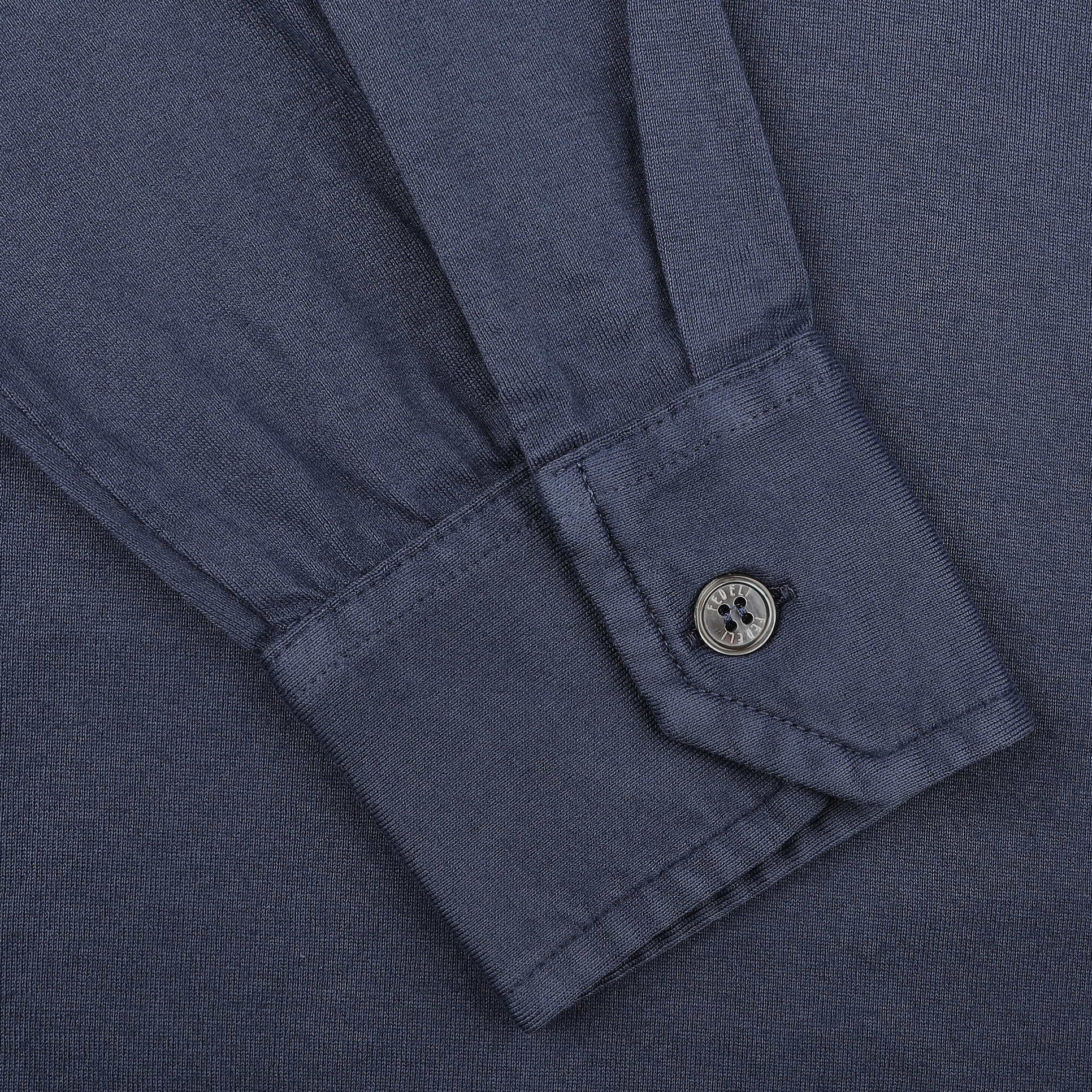Close-up of a Dark Blue Organic Cotton LS Polo Shirt by Fedeli, highlighting the long-sleeved cuff with a single button.