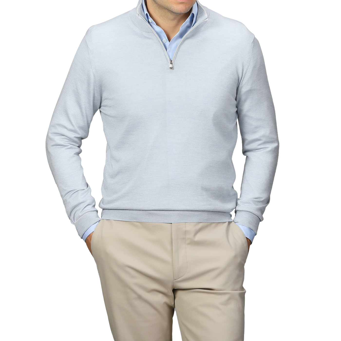 A person wearing a Fedeli Sky Blue Cashmere Silk 1/4 Zip Sweater stands with hands in pockets against a plain background, complemented by a light gray shirt and beige pants.