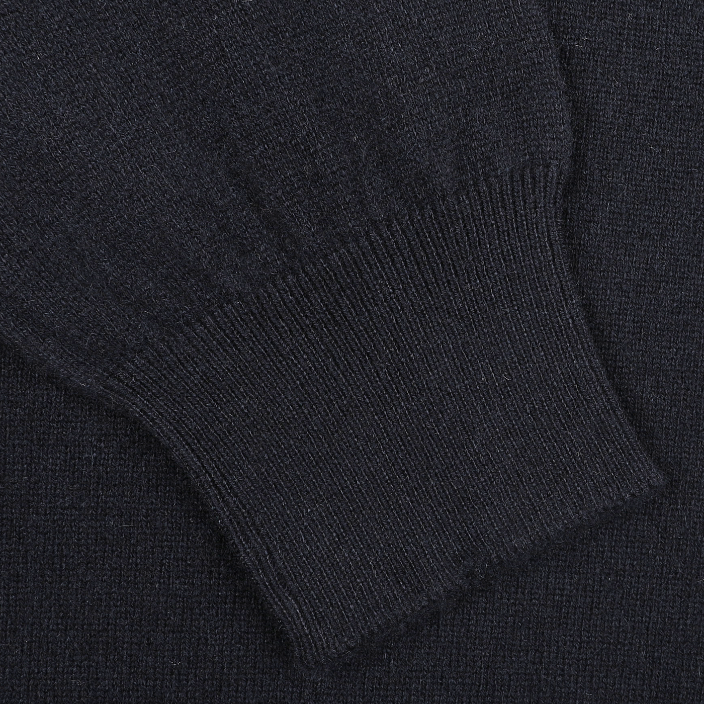 Close-up of a navy blue Gran Sasso crew neck sweater sleeve, highlighting the ribbed cuff and luxurious softness of cashmere fibers.