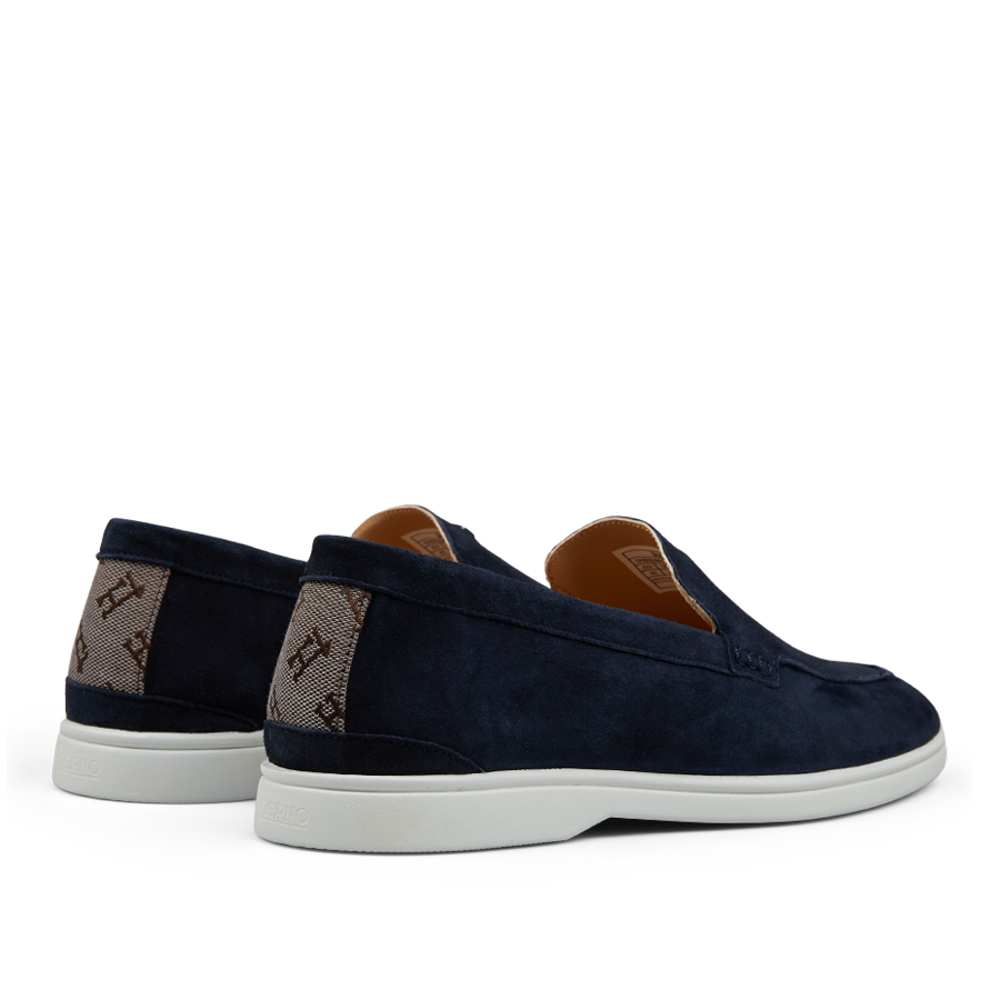 A pair of dark blue Herno suede slip-on loafers with white soles and branded canvas panels on the sides.
