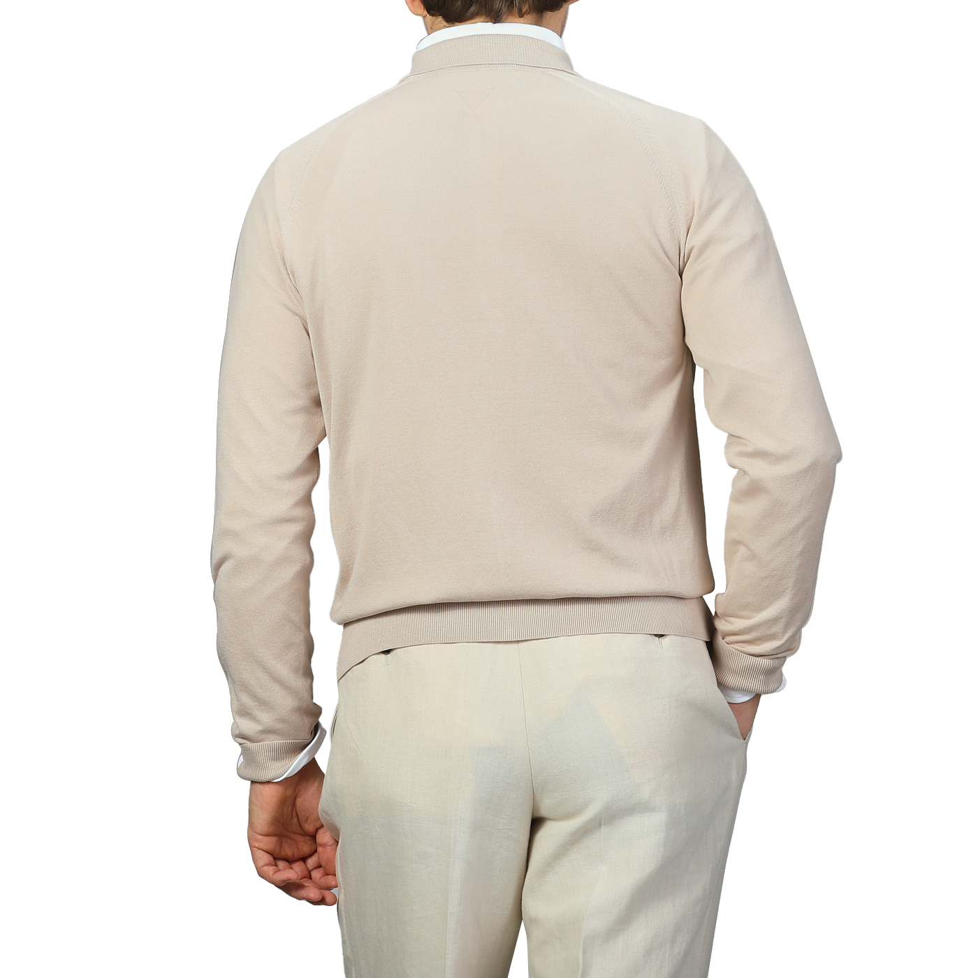 Against a plain background, a person embodies the subtle elegance of Italian knitwear while wearing Maurizio Baldassari's Beige Silk Cotton Full Zip Tennis Polo Shirt paired with light-colored pants, shown from the back.