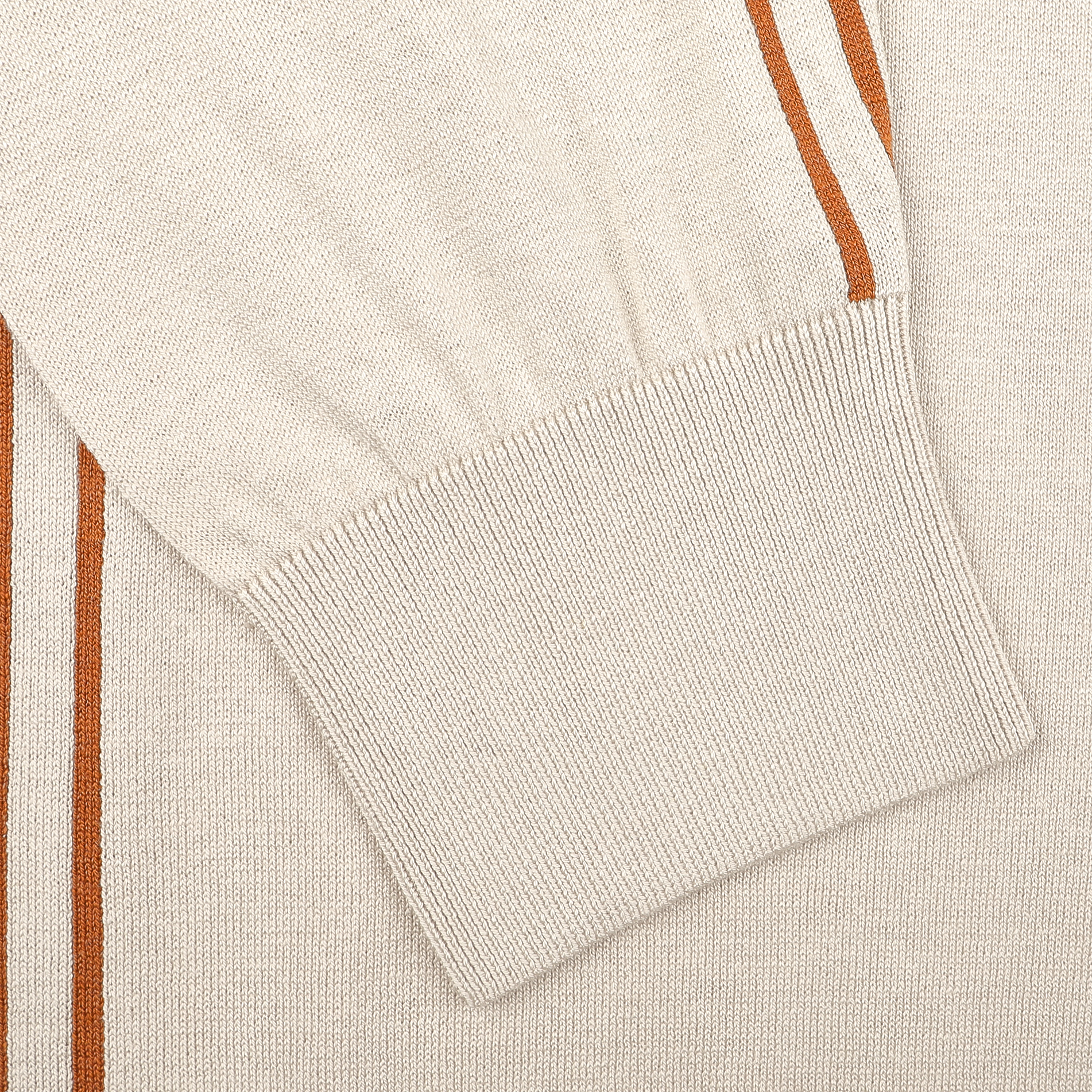 Close-up of a beige sleeve from the Maurizio Baldassari Silk Cotton Full Zip Tennis Polo Shirt, boasting ribbed cuffs and orange-brown vertical stripes on a textured fabric.