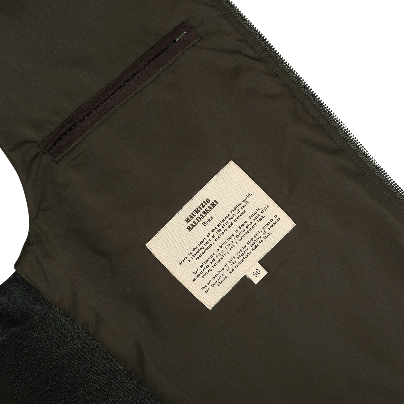 Close-up of a label on the inside of a Maurizio Baldassari Dark Green Water Repellent Cashmere Gilet, displaying care instructions for cashmere and a sizing label marked "50" on greenish-brown material, with a zipper and pocket visible.