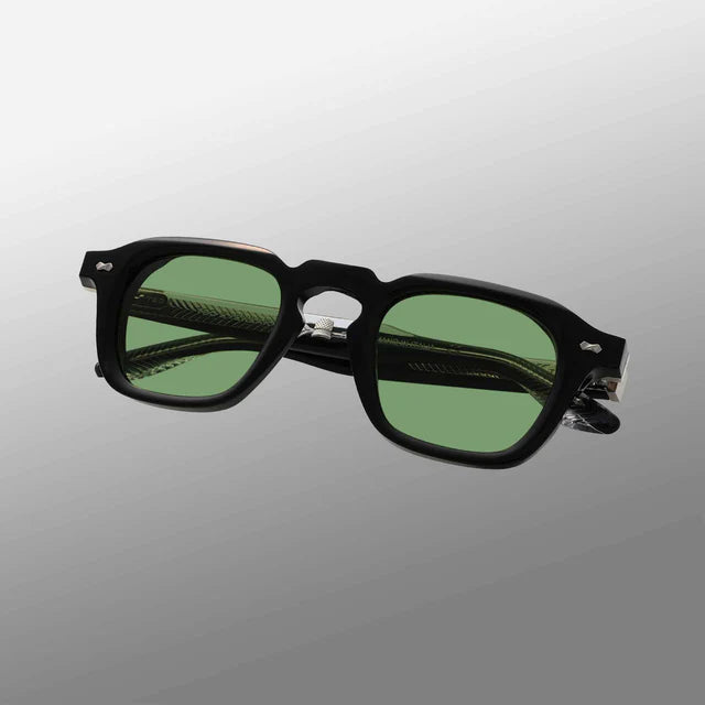 The Ply Black | Green sunglasses by TBD Eyewear feature square black frames and green-tinted lenses, handcrafted in Italy. Shown against a light gray gradient background, both lenses and the thick folded arms are visible at a slight angle. , available at Richard Gelding Mayfair