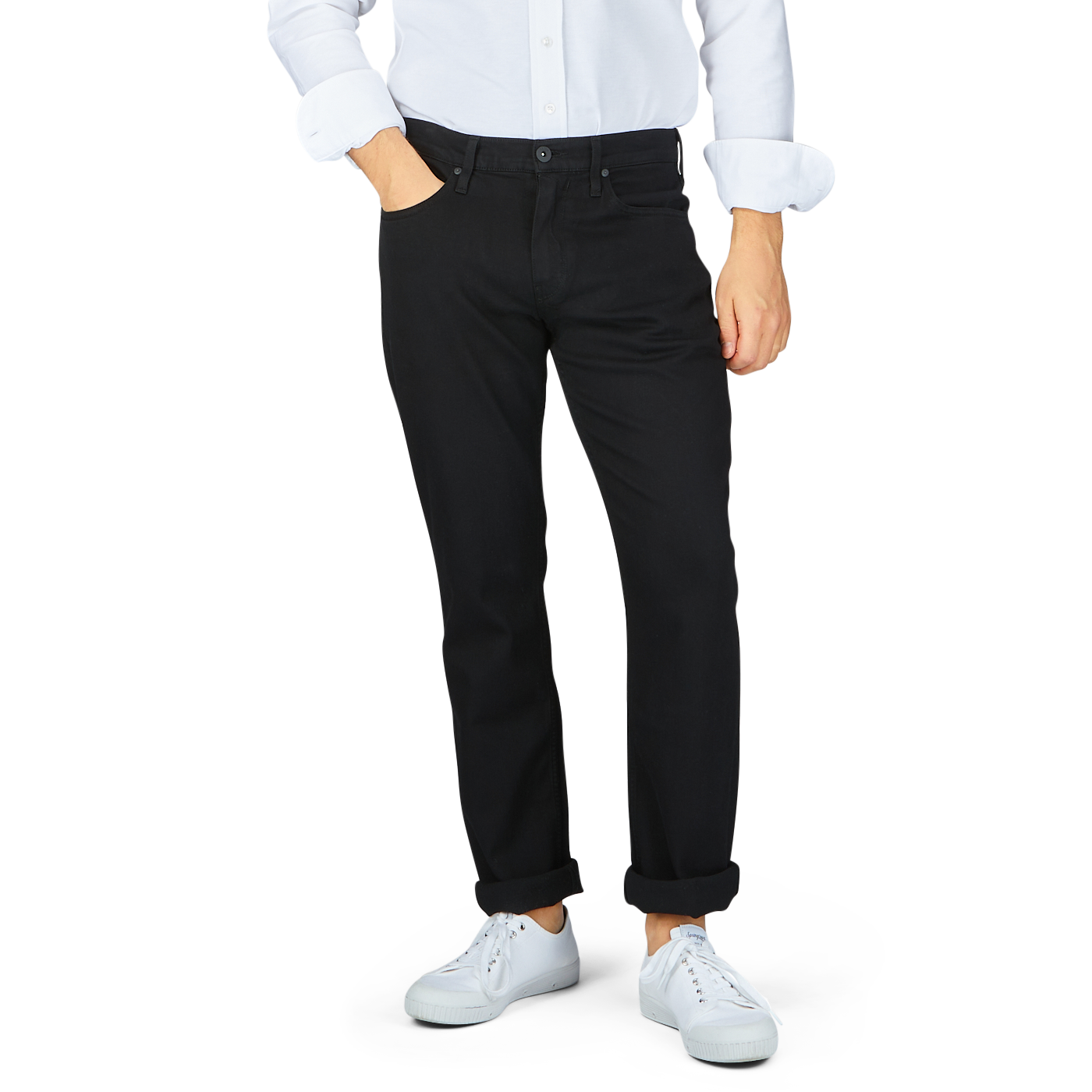 Man wearing Paige Black Shadow Cotton Transcend Normandie Jeans with a white shirt and white sneakers.