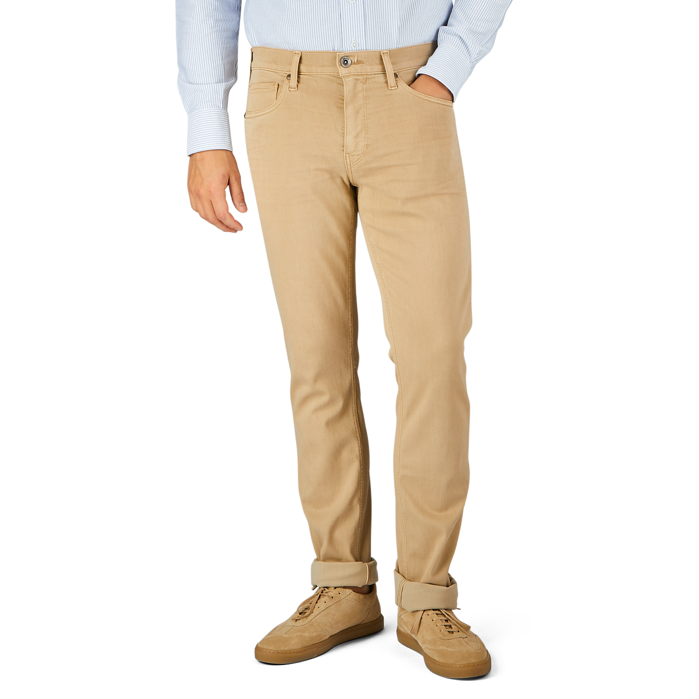 A person wearing a light blue shirt, Caramel Beige Cotton Transcend Federal Slim Jeans from Paige rolled up slightly at the bottom for a comfortable fit, and beige shoes stands against a plain background.