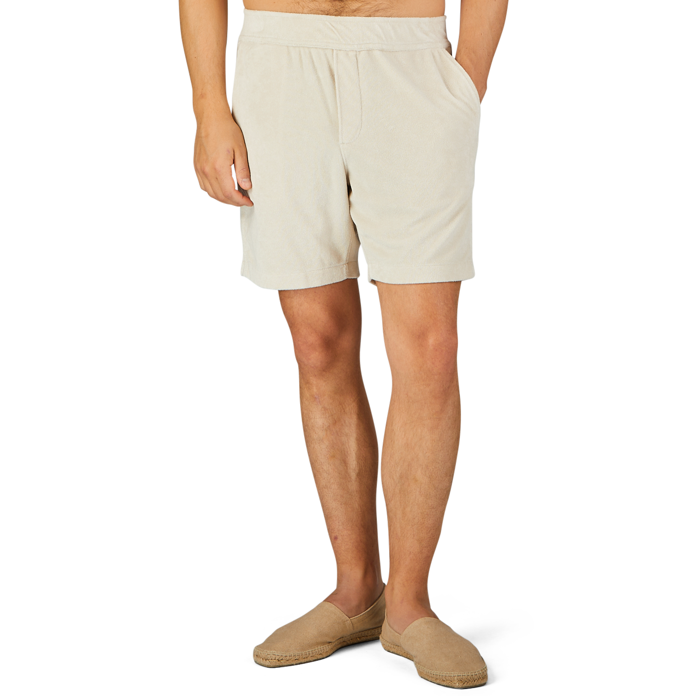 A person wearing Paige's Cream Beige Cotton Towelling Shorts with a drawstring waist and beige slip-on shoes is standing against a plain background with one hand in their pocket.