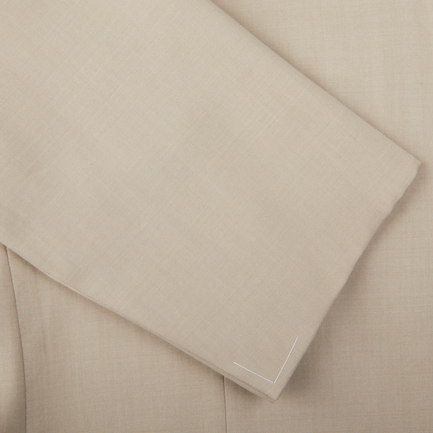 A close up image of a light beige Ring Jacket suit made of herringbone wool.