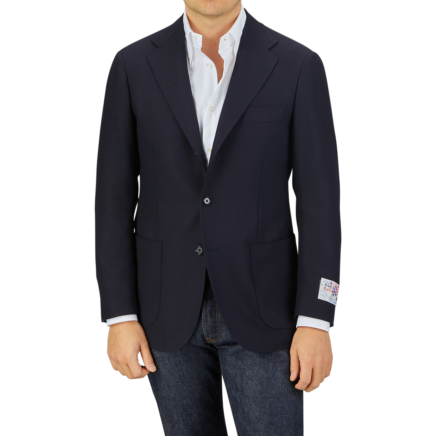 Man wearing a Ring Jacket Navy Blue Wool Balloon Travel Blazer over a white shirt paired with jeans, standing against a gray background.