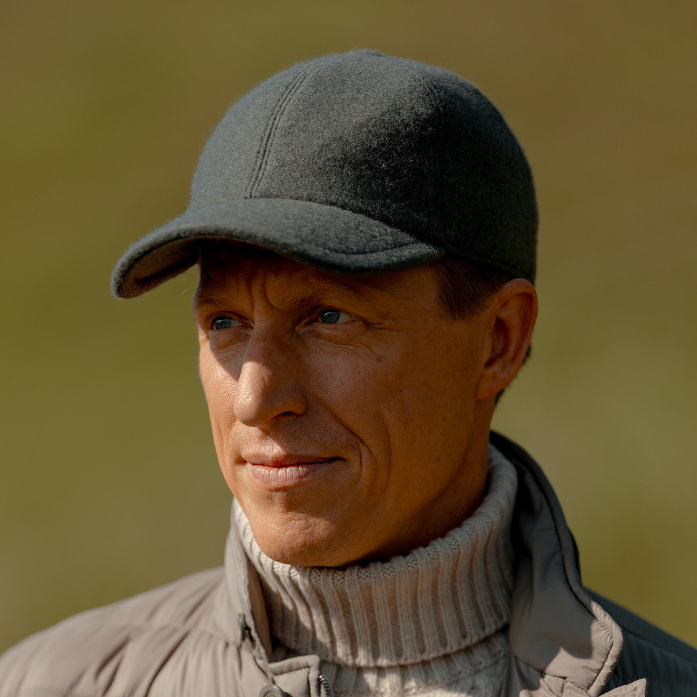 A man wearing a Wigéns Grey Loro Piana Wool Cashmere Baseball Cap and a sweater.