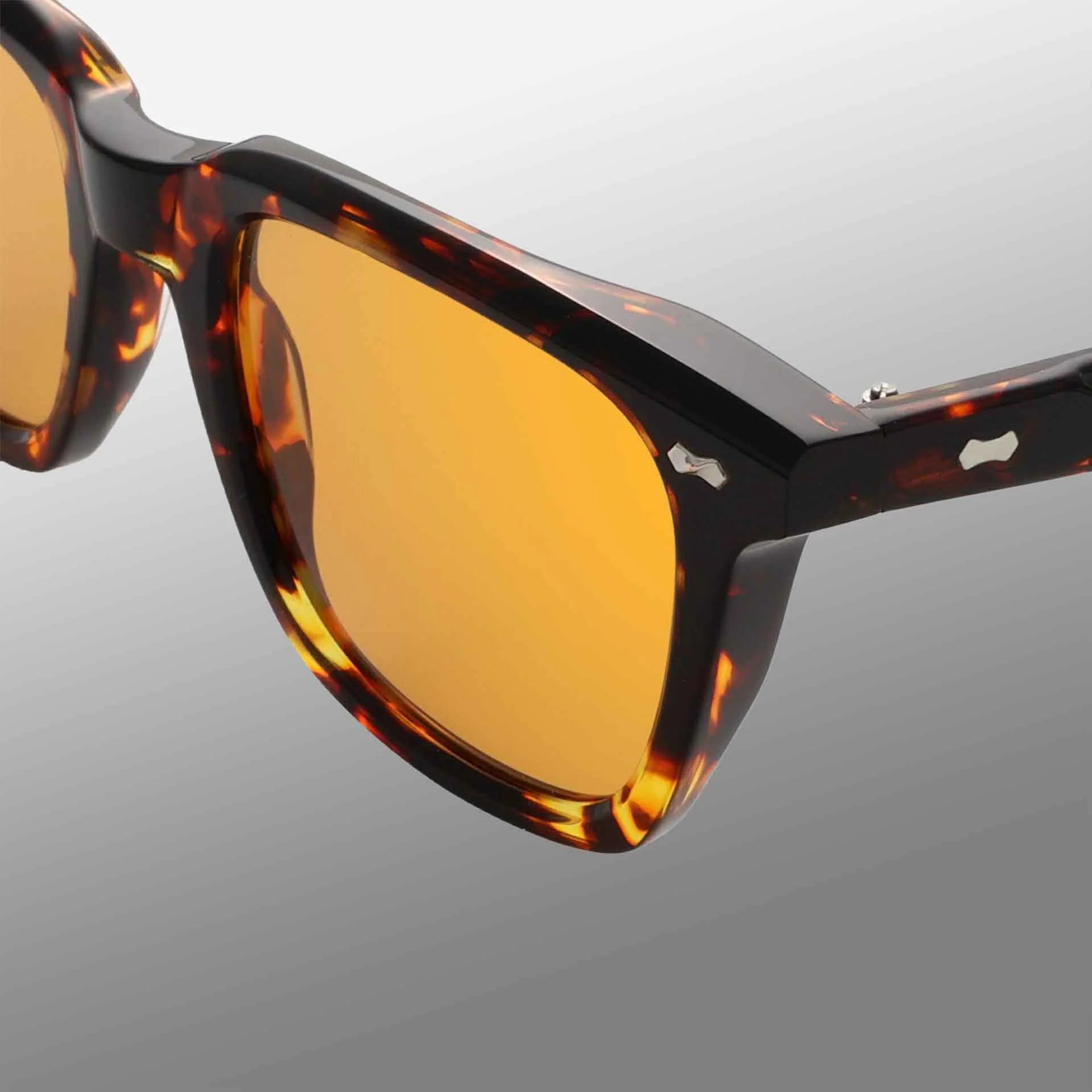 Close-up of TBD Eyewear's Carré Eco Dark Havana | Orange sunglasses, featuring a tortoiseshell-patterned frame with orange lenses and subtle silver detail at the hinge, set against a smooth gray gradient background. , available at Richard Gelding Mayfair
