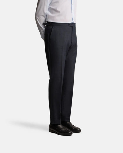A person in a Cavour Navy Check Hightwist Wool Suit stands with hands by their sides in black leather dress shoes against a plain white background. , available at Richard Gelding Mayfair