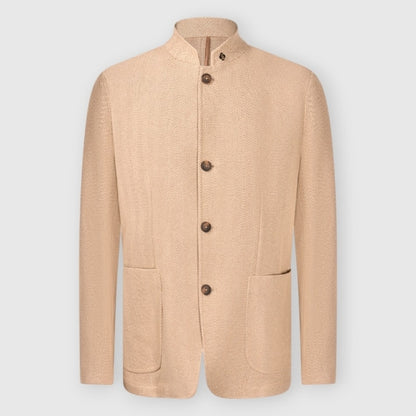 The Gran Sasso Beige Herringbone Cotton Blend Jacket features a mandarin collar, four large brown buttons, two front patch pockets, and textured fabric for depth. Its tailored yet relaxed fit is showcased against a plain light gray background. , available at Richard Gelding Mayfair