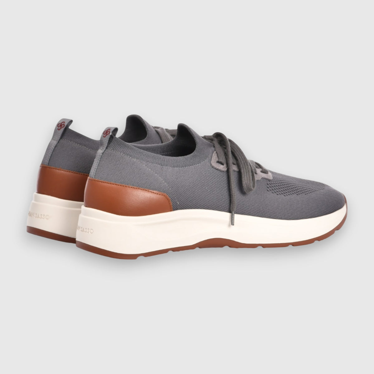 The Gran Sasso Grey Knitted Sneaker features a breathable knit upper, grey laces, brown heel accents, white midsoles, and brown outsoles. Shown on a light grey background with views of the side and back. , available at Richard Gelding Mayfair