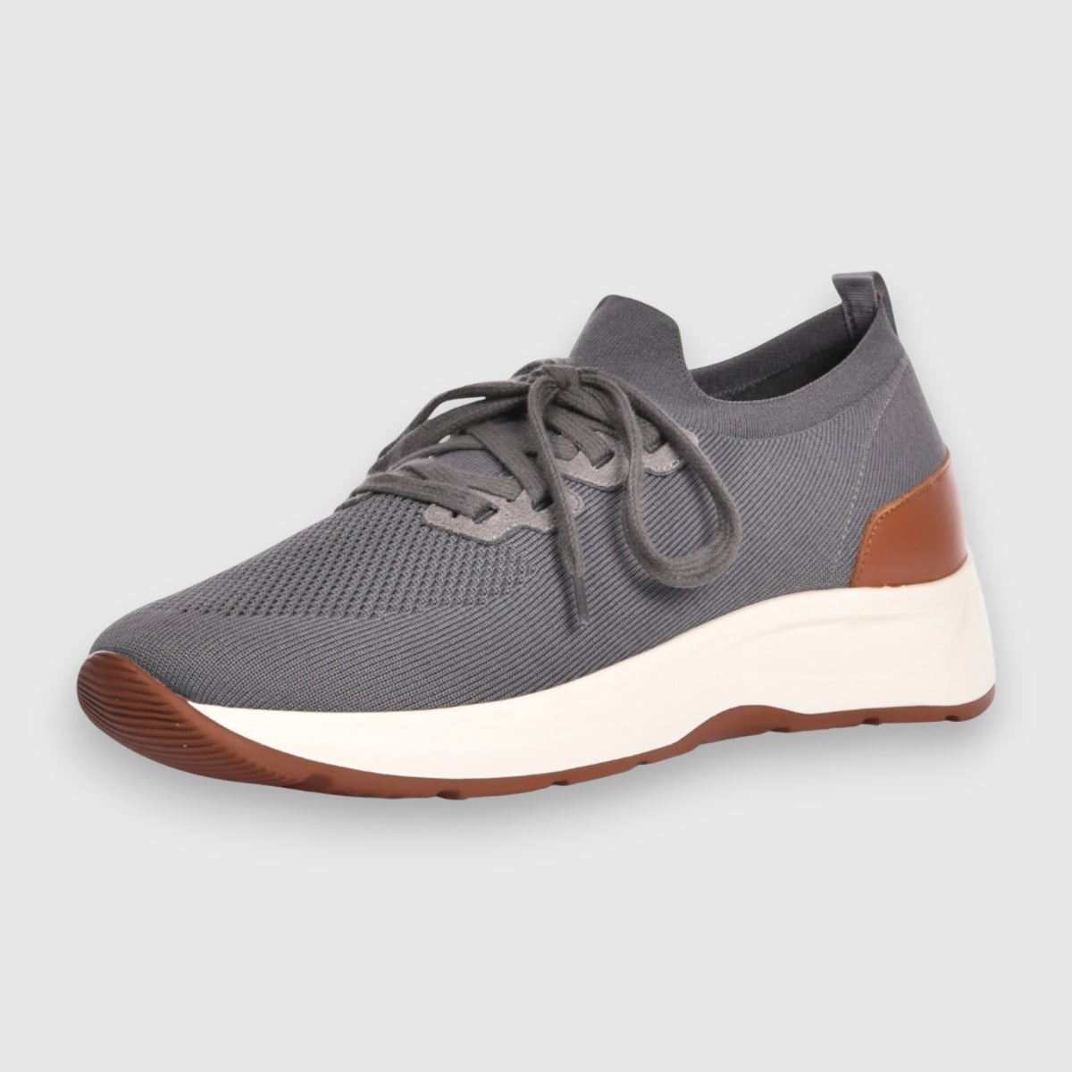 The Gran Sasso Grey Knitted Sneaker features a breathable mesh upper, round toe, matching laces, thick white sole, and brown heel accents. A light gray background highlights this comfortable shoe’s sleek details. , available at Richard Gelding Mayfair