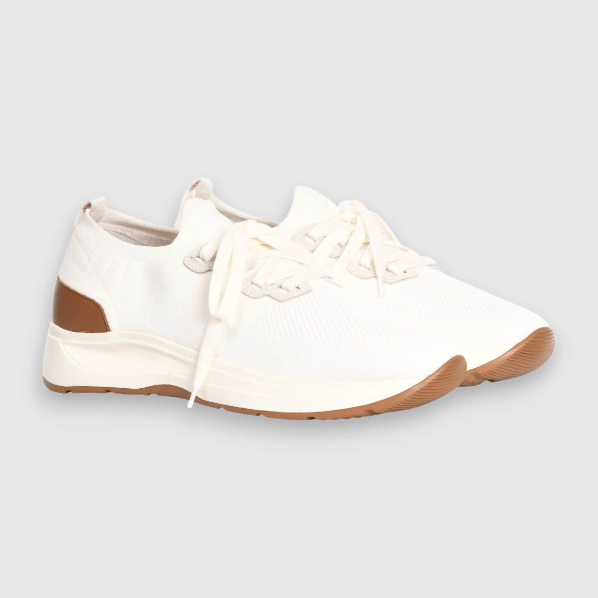 The Gran Sasso White Knitted Sneaker features a breathable knit design with cream laces, a brown leather heel accent, and a tan rubber sole—ideal for comfortable walking on any casual outing. , available at Richard Gelding Mayfair