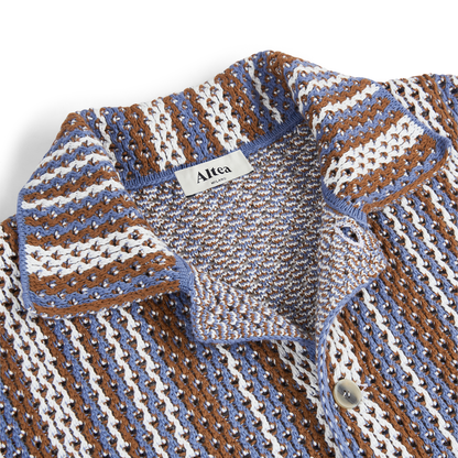 Close-up of the Altea Brown Blue Cream Cotton Knitted Polo, featuring textured fabric with blue, brown, and cream vertical stripes, a classic collar, a white button, and a branded white Altea label at the neckline. , available at Richard Gelding Mayfair