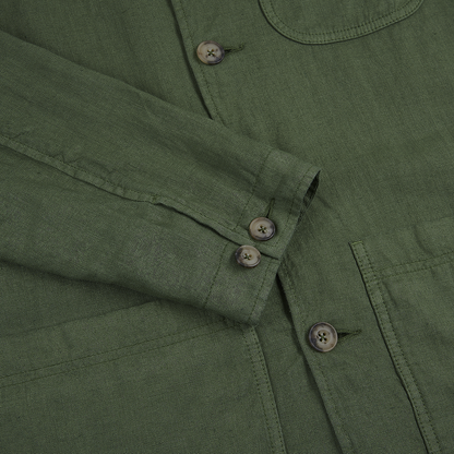 Close-up of the Altea Army Green Linen Chore Jacket, highlighting the sleeve crossed over the front, visible stitching, three brown cuff buttons, and a large brown button by a patch pocket. , available at Richard Gelding Mayfair