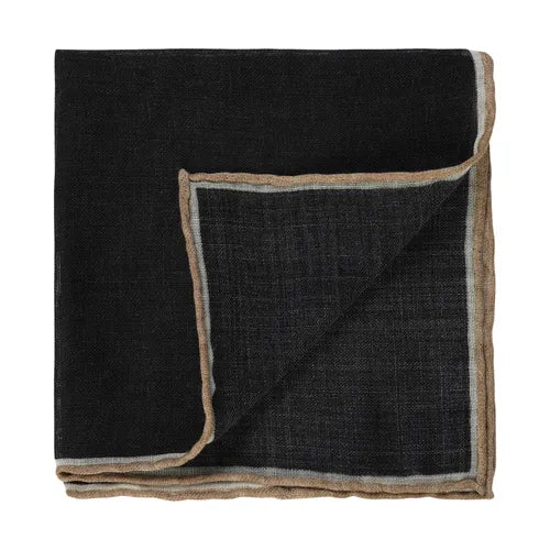 An Amanda Christensen wool pocket square with hand rolled edges is folded neatly with one corner turned up, showcasing its double-layered printed texture. The edges feature a delicate light brown trim for contrast, all set against a plain white background. , available at Richard Gelding Mayfair