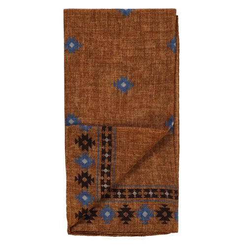 A folded brown wool bandana by Amanda Christensen, featuring a subtle texture and scattered small blue diamond patterns. One edge is accented with a black border adorned with blue and black geometric Inca-inspired designs, creating a striking contrast. , available at Richard Gelding Mayfair