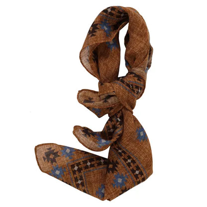 An Amanda Christensen wool bandana with an Inca pattern print is tied in a loose knot. The scarf appears lightweight and features a soft, textured fabric, creating an elegant yet casual look. , available at Richard Gelding Mayfair