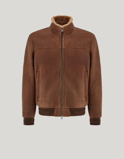 The Canali Brown Merino Shearling Lambskin Suede Blouson features a front zipper, shearling-lined collar, ribbed cuffs and hem, and two side pockets, showcased against a neutral gray background. , available at Richard Gelding Mayfair