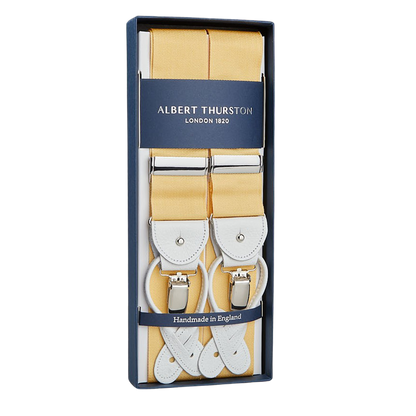 The package contains "Champagne Nylon Leather 40mm Braces" with white leather details and silver clasps by Albert Thurston, labeled "Albert Thurston London 1820," a renowned British brand famous for exquisite handmade braces, marked "Handmade in England.