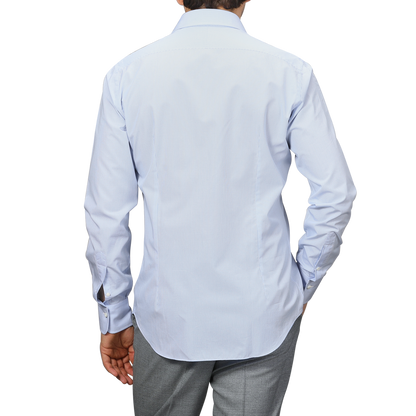 A person in a blue gingham checked cotton shirt by Alessandro Gherardi is shown from the back, paired with gray pants.