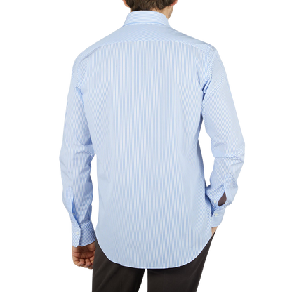 The back view of a man wearing a blue shirt, showcasing the Alessandro Gherardi Sky Blue Striped Cotton Single Cuff Shirt.