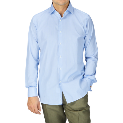 A man wearing a fitted cut, Alexander Kraft Monte Carlo Blue White Bengal Stripe Cotton Double Cuff Shirt and green pants.
