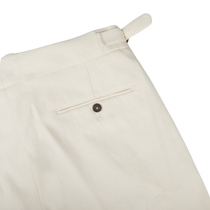 A close-up of Alexander Kraft Monte Carlo Cream White Cotton Twill Updated Gurkha Trousers with buttons, perfect for formal attire.