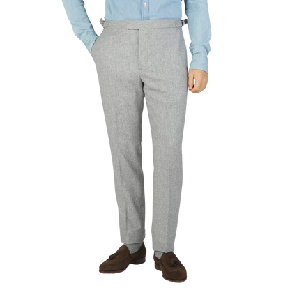 A man wearing Light Grey VBC Wool Flannel Riviera Trousers made by Alexander Kraft Monte Carlo and a blue shirt.