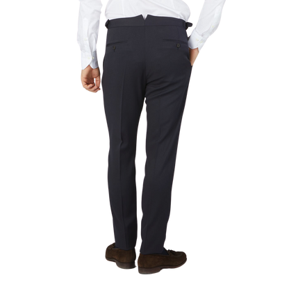 The back view of a man wearing a Navy Blue Textured Worsted Wool Riviera Trousers by Alexander Kraft Monte Carlo with formal trousers.