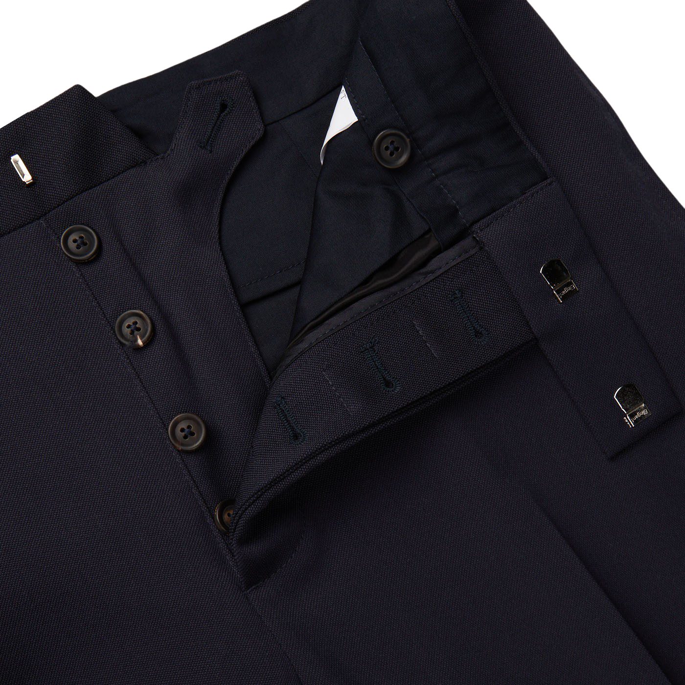 A pair of Alexander Kraft Monte Carlo Navy Blue Textured Worsted Wool Riviera Trousers with buttons on the side.
