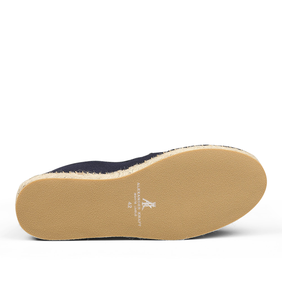 The underside of a shoe with a light brown sole features white text indicating the brand and size "42." The upper part, crafted in dark blue cotton, exudes the luxurious appeal of Alexander Kraft Monte Carlo Dark Blue Cotton Luxury Espadrilles, with only a partial view hinting at their elegance.